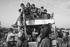 People crowd onto a truck at the entrance of an illegal dirt road connecting Colombia and Venezuela in Paraguachón, La Guajira, Colombia, on July 6, 2018. 
The 2219 km-long frontier between the two countries only counts on seven official immigration checkpoints (UNHCR). Venezuelan refugees and migrants are exposed to abuse, trafficking, and recruitment in no man's borderlands, where illegal groups control people's movement and smuggling. 
Since 2018, when the migration crisis worsened, dozens of thousands of Venezuelan families set up tent cities on the outskirts of indigenous towns. By documenting the constant movement of people at the border and the intolerable living conditions in the informal camps, the photographer felt two collapsing worlds were colliding in a region already suffering from extreme poverty. 
At this crossing point, cars and trucks used to stop to let people get in and out, an opportunity for Wayuu children to sell water and snacks, and for the photographer to briefly exchange words with the people on the move, and share his intentions for photographing.